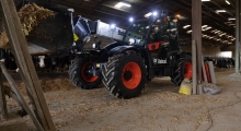 Телескопический погрузчик для сельского хозяйства Bobcat TL43.80HF+AGRI работает в коровнике.