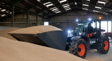 Телескопический погрузчик для сельского хозяйства Bobcat TL43.80HF+AGRI работает с сыпучими материалами.