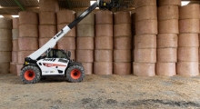 Телескопический погрузчик для сельского хозяйства Bobcat TL43.80HF+AGRI укладывет снопы.