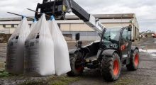 Телескопический погрузчик для сельского хозяйства Bobcat TL43.80HF+AGRI с вилами в работе.